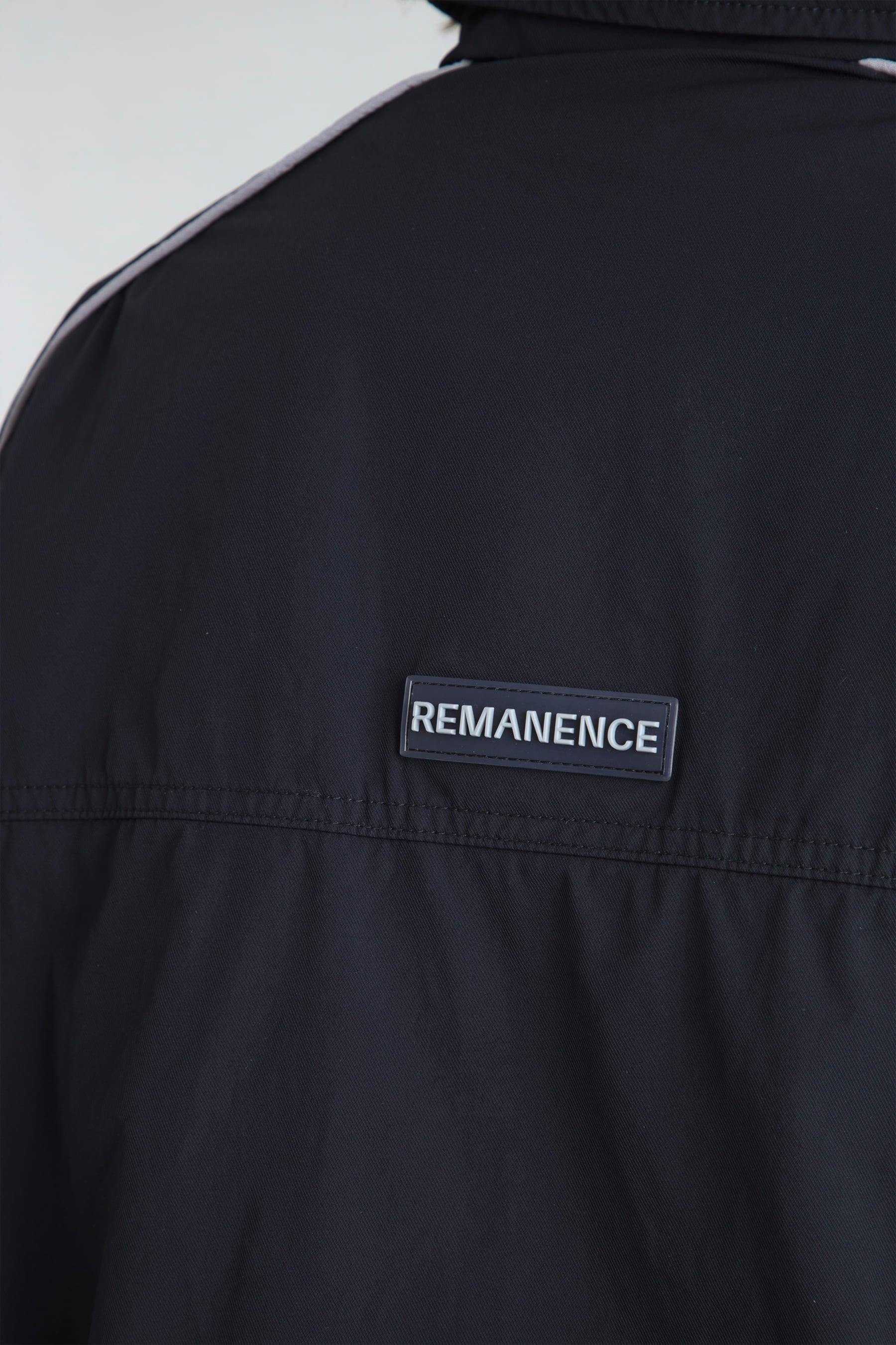Remanence logo detail on women's black jacket