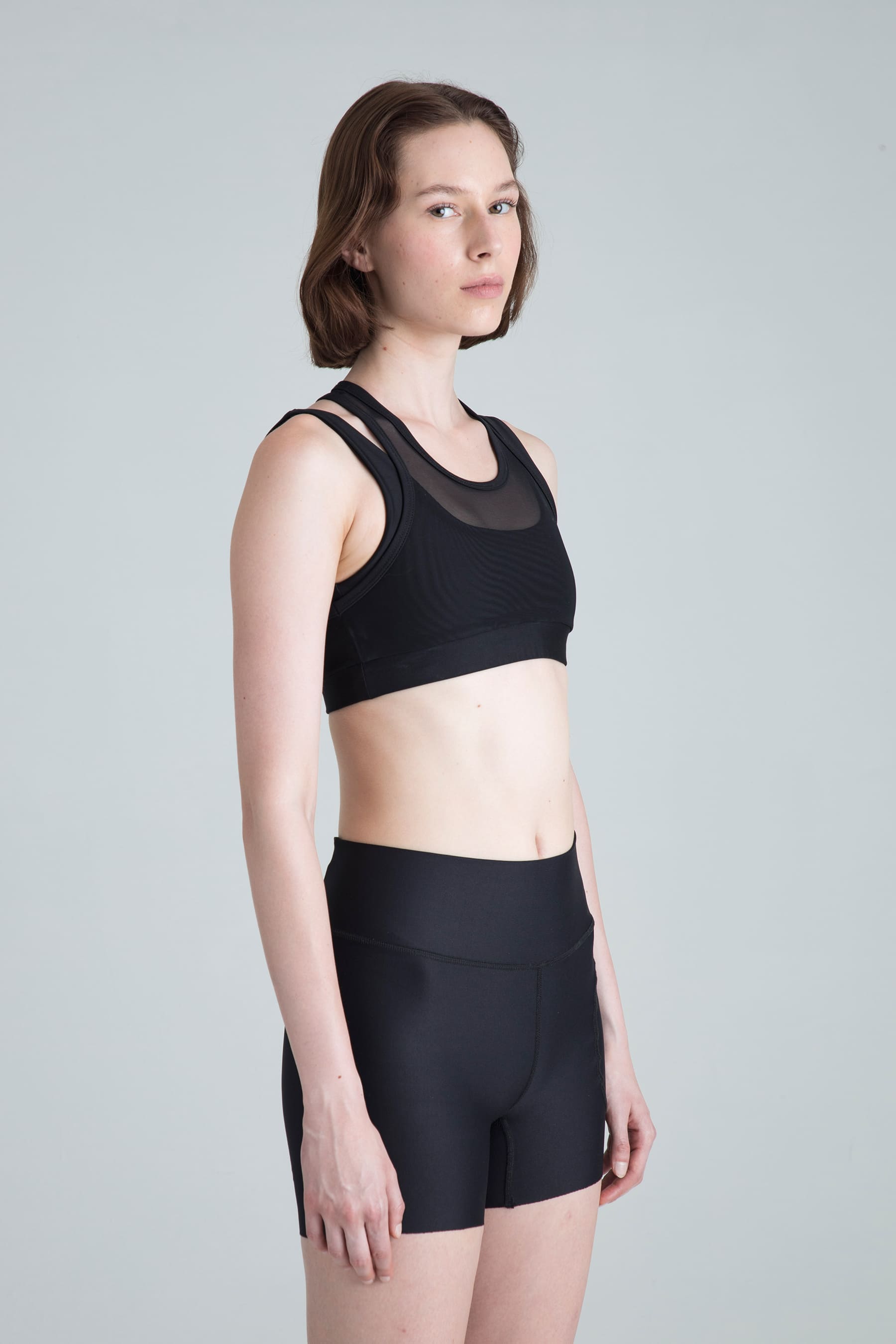 Women's black sports top Apex side profile on model